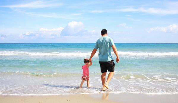 Dad and daughter on the beach by the sea