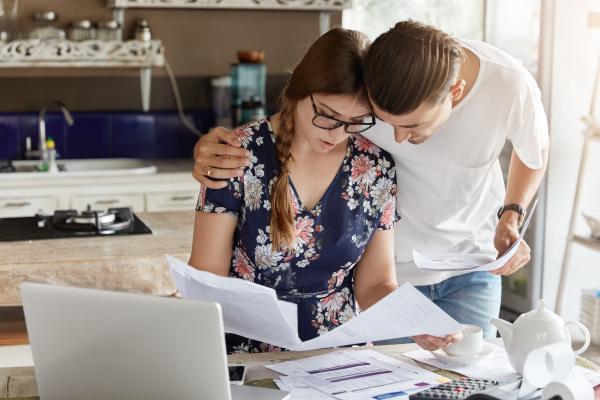 couple worried about their money and reviewing bank statements